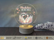 a personalized glass ornament with a couple of swans on it