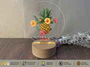 a glass display with a pineapple and flowers on it