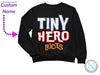 a black sweatshirt with the word tiny hero on it