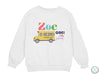 a white sweatshirt with a yellow school bus on it