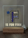 a glass block with the letter f is for finn